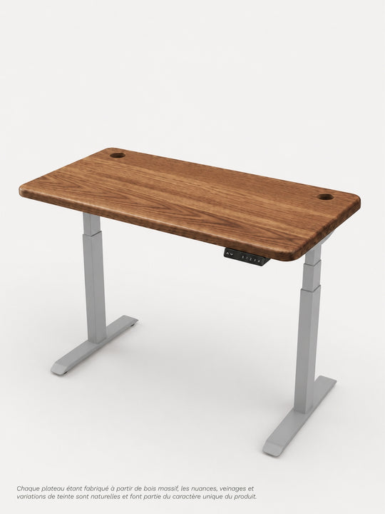 Vue de trois quarts du bureau Assis Debout AUM WORLD ADVANCED GO avec piètement gris RAL 9006 et plateau PREMIUM OAK en chêne massif Made in France.